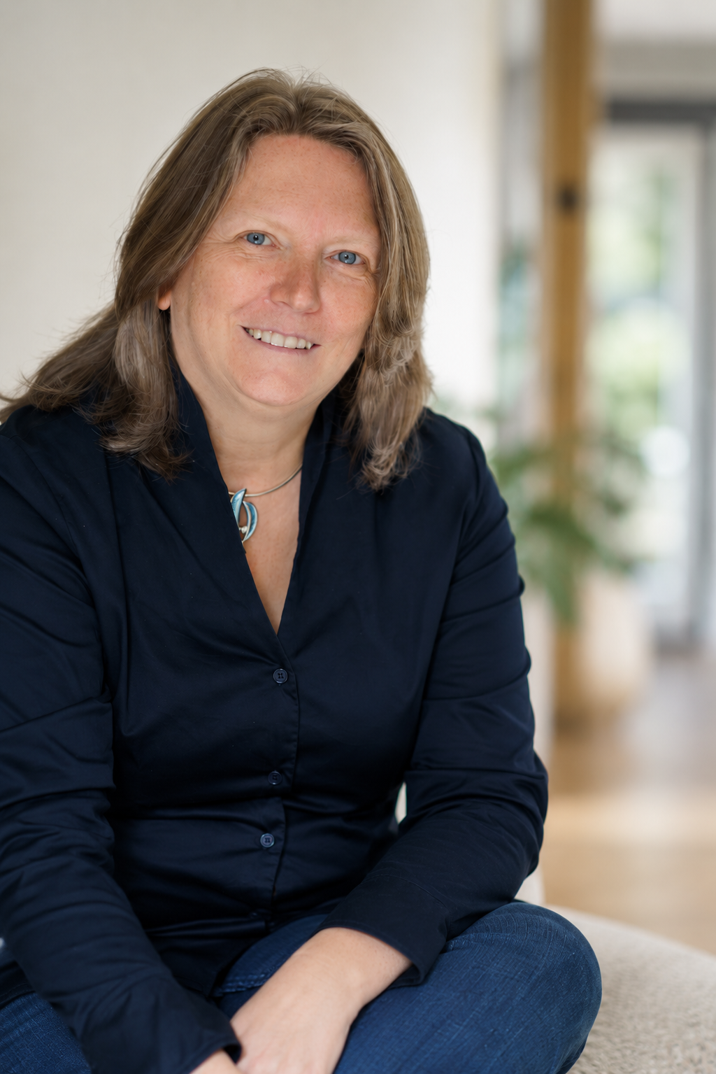 Julie Goddard, leadership psychologist and creator of i3 Leadership, sitting and smiling at the camera